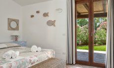 Villa Campidano 8 | Schlafzimmer 1 mit Doppelbett und Tür zum Garten Schlafzimmer und Garten