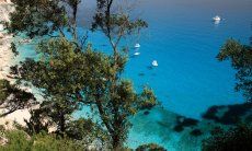 Blick von oben durch die Wacholderbäume auf das blaue Meer von Cala Goloritze; Cala Luna