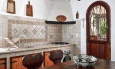 Villa Liliana | Küche im Landhausstil mit Ofen und Herd und Esstisch aus Holz Küche im Landhausstil mit Ofen und Herd und Esstisch aus Holz