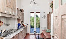 Vollausgestattete Küche mit kleinem Esstisch und Terrassenzugang 