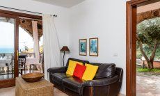 Apartment Castededdu 2 | Wohnbereich mit Sofaecke und Eingangstür Wohnbereich mit Sofaecke und Eingangstür