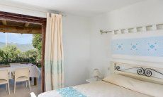 Villa Oleandro | Schlafzimmer mit Tür zum Garten mit sardischen Stoffen dekoriert Schlafzimmer mit sardischen Stoffen dekoriert