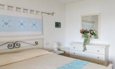 Villa Oleandro | Schlafzimmer mit Doppelbettt, Kommode und Spiegel Schlafzimmer mit Ehebett, Kommode und Spiegel