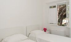 Villa Pola | Schlafzimmer 4 mit zwei Einzelbetten und Fenster zum Garten Schlafzimmer 4 mit zwei Einzelbetten und Fenster zum Garten