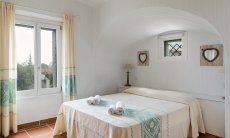 Li Conchi 30 | Schlafzimmer 1 mit Wandbogen und Fesnter zum Garten Hausdarstellung von Li Conchi 30