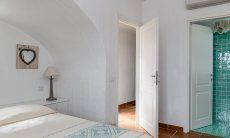 Li Conchi 30 | Schlafzimmer 1 mit Eingangstür und Tür zum privaten Bad Hausdarstellung von Li Conchi 30