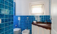 Li Conchi 30 | Blau gekacheltes Bad 2 mit Waschbecken, Toilette, WC, Dusche und Fenster Hausdarstellung von Li Conchi 30