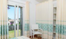 Li Conchi 34 | Schlafzimmer 1 mit Doppelbett, Wandschrank und Fenstertür zum Garten Hausdarstellung Li Conchi 34, Cala Sinzias