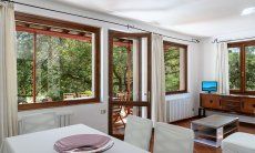 Casa Su Faru 2 | Große Fensterfront mit Blick ins Grüne und Tür auf die Terrasse direkt vom Wohnzimmer Große Fensterfront mit Blick ins Grüne vom Wohnzimmer von Su Faru 2 Pula