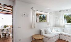 Casa Su Faru 3 | Sofaecke im Wohnzimmer mit Blick ins Grüne und auf die Terrasse Sofaecke im Wohnzimmer mit Blick in Grüne und auf die Terrasse von Su Faru 3 Pula