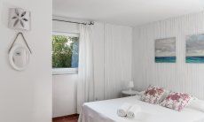 Casa Su Faru 3 | Schlafzimmer 1 mit Doppelbett und Fenster mit Blick in den Garten Schlafzimmer mit Doppelbett und Fenster ins Grüne Su Faru 3 Pula