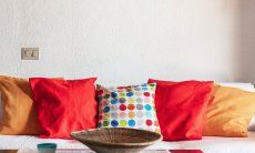 Apartment Nido 2 | Bunte Dekokissen auf dem Sofa Nido 2, Costa Rei, Südsardinien