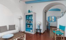 Casa 17 | Wohzimmer mit elegantem Sofa und praktischem Bücherregal, Torbogen zur Wohnküche Casa 17, Sant Elmo, Südsardinien