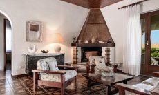 Villa Palme | Wohnzimmer mit großem Kamin und Terrassentür Wohnzimmer mit Eckkamin, Villa Palme, Costa Rei