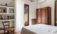 Villa Palme | Schlafzimmer 1 mit Doppelbett, Klimaanlage und Bücherregal Villa Palme, Costa Rei