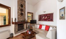 Villa Tiziana 11 | Gemütliche Sofaecke mit TV und offenem Kamin für die Nebensaison sowie Klimaanlage für die heißen Tage Hausdarstellung