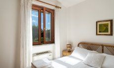 Villa Tiziana 11 | Schlafzimmer 1 mit Doppelbett, Klimaanlage und Blick ins Grüne Hausdarstellung