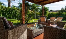 Villa Romana | Kunstrattansofa und Sonnenliegen auf der seitlichen Terrasse Außenbereich mit Garten und Terrasse