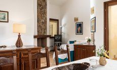 Villa Gioconda 21 | Rustikaler Esstisch und -möbel mit Blick in die Sofaecke im Wohnzimmer Hausdarstellung