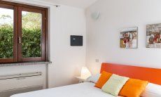 Villa Sandra 43 | Schlafzimmer 1 mit Doppelbett, Blick in den Garten und Klimaanlage Hausdarstellung