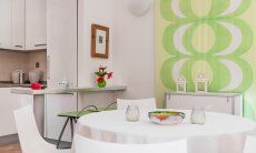 Villa Sandra 43 | Runder Esstisch und Blick in die Küche Hausdarstellung