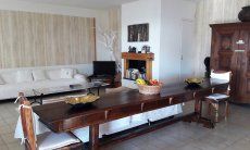 Villa Ulivi 27 | Wohnzimmer mit großem Tisch und Innenkamin V. Ulivi 27
