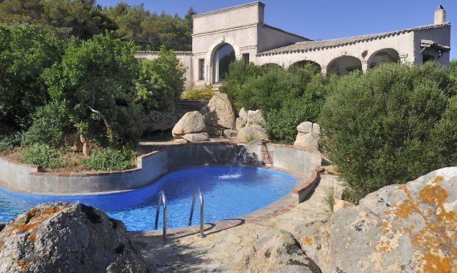 Villa Is Molas Monte | Der Pool ist bohnenförmig und inmitten von Granitfelsen und grüner, mediterraner Pflanzen neu