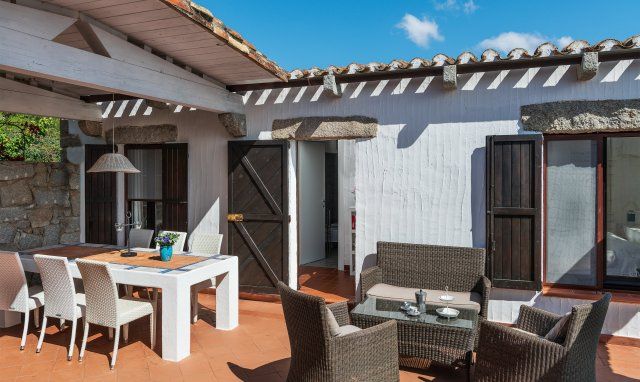 Casa 14 | Teilüberdachter großer Innenhof mit Esstisch und Sofamöbeln Casa 14, Sant Elmo, Sardinien
